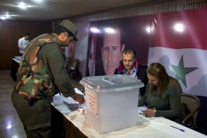 A Syrian policeman casts his vote at a polling station during the parliamentary election in Damascus, Syria, Wednesday, April 13, 2016. Polling stations opened in government-held parts of Syria where a new 250-member parliament will be elected. (AP Photo/Hassan Ammar)