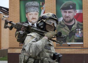 Interior ministry officer walks with a machine gun during exercises in the village of Tsentoroi, 80 km (50 miles) southeast of Chechnya's provincial capital Grozny, Russia, Saturday, April 16, 2016. In the back, portraits of Chechen regional leader Ramzan Kadyrov, right, and his father Akhmad Kadyrov, the Chechen president who was assassinated in a 2004 bomb blast. (AP Photo/Musa Sadulayev)
