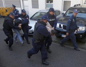 Montenegrin police officers escort men for questioning, in Podgorica, Montenegro, Sunday, Oct. 16, 2016. Rising tensions amid a crucial election, Montenegrin police say they have arrested 20 people who are suspected of planning armed attacks after the vote that could determine whether the small Balkan state continues on its Western course or turns back to traditional ally Russia. (AP Photo/Darko Vojinovic)